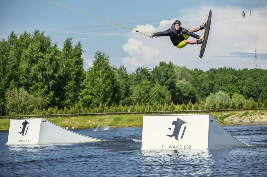 Wakeboarder catching air off a HI WAKE 5.0 branded kicker ramp at the park